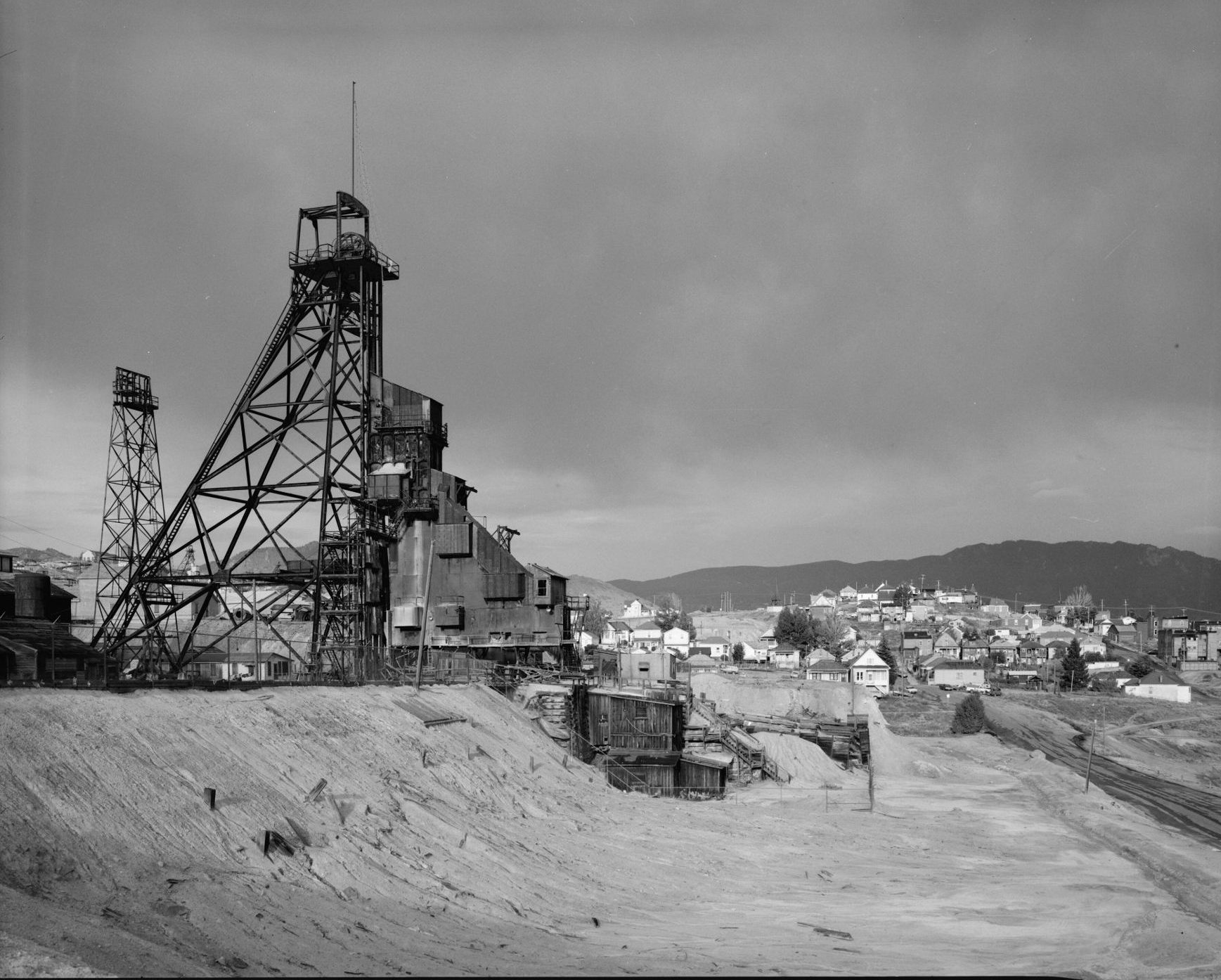 Steel headframe and ore tipple of the Anselmo Mine in Butte, the town spread across the hills behind